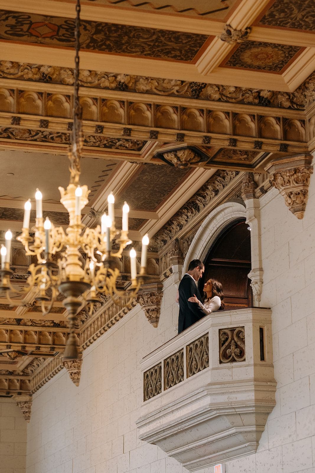 The Juliet balcony today, beneath a lit chandelier and the restored coffered ceiling