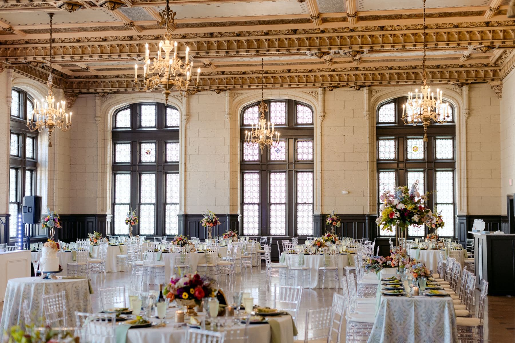 The ballroom set for dinner under lit chandeliers